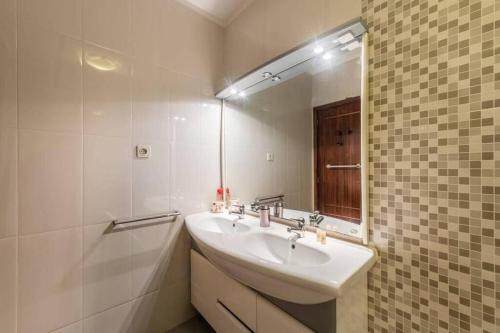 a bathroom with a sink and a mirror at Sunset Apartment Vila Nova de Gaia in Vila Nova de Gaia