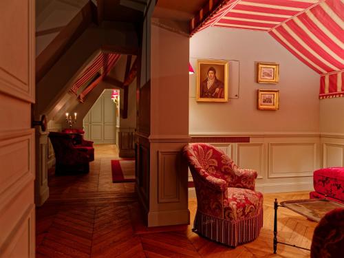 a hallway with a chair and a painting on the wall at Relais & Château Louise de La Vallière in Reugny