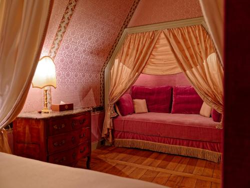 a bedroom with a bed and a lamp on a dresser at Relais & Château Louise de La Vallière in Reugny