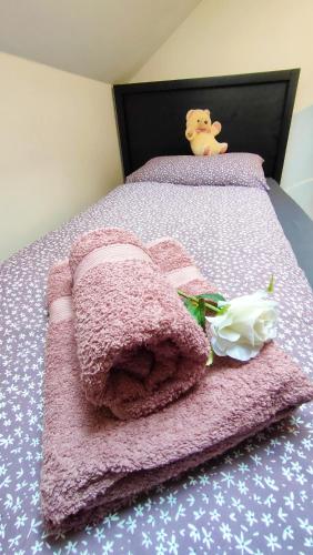 a pink blanket on a bed with a white flower at Apartmaji Dora in Mojstrana