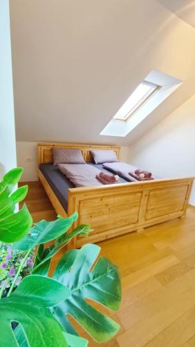a bedroom with a wooden bed with a skylight at Apartmaji Dora in Mojstrana