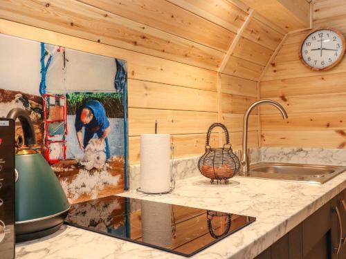 a kitchen with a sink and a clock on the wall at The Shearer - Crossgate Luxury Glamping in Penrith