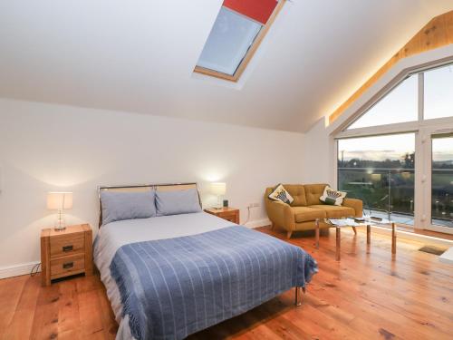 um quarto com uma cama, um sofá e uma janela em Upper Annex em Calne