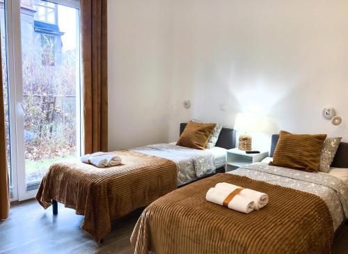 Zimmer mit 2 Betten, braunen Decken und einem Fenster in der Unterkunft Chummy House Sopot in Sopot