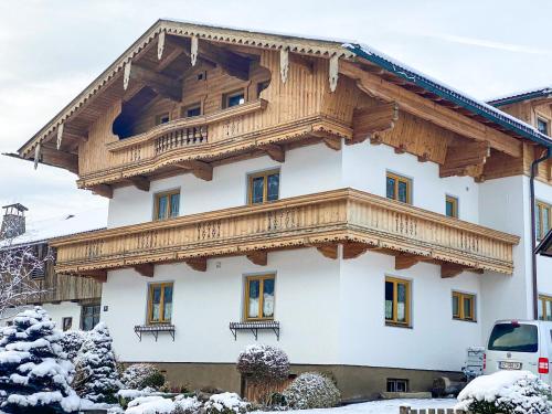 a large white building with a wooden roof at Ferienhaus Wachterhof Aschau im Zillertal in Aschau