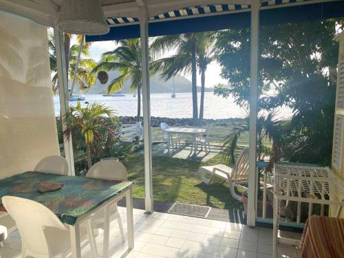 - une terrasse couverte avec une table et une vue sur l'océan dans l'établissement Bungalow Anolis face à la mer à 2 min de la plage., à Terre-de-Haut
