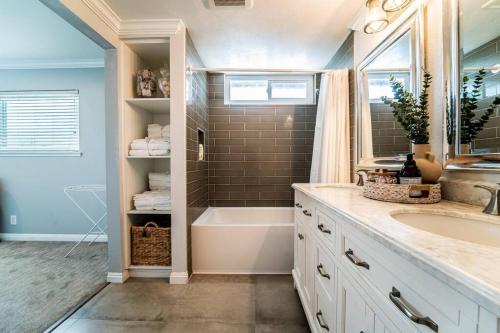 a bathroom with a tub and a sink and a bath tubermott at Private Pool Oasis/Disney 15mins /Disney+ HBO/Gym in Placentia
