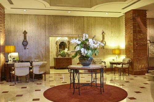 a lobby with a table with a vase of flowers on it at L'Hotel PortoBay São Paulo in Sao Paulo
