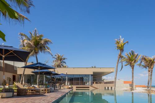 a resort with a swimming pool and palm trees at Saline Taíba Boutique Beach Hotel in Taíba