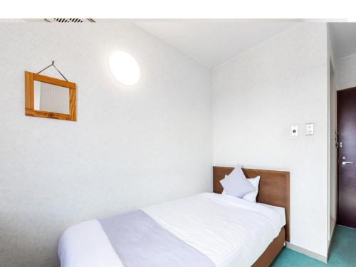una camera con letto bianco e specchio di HOTEL SHAROUM INN - Vacation STAY 04959v a Hakodate