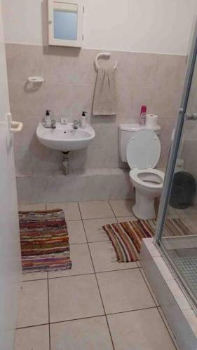 a bathroom with a toilet and a sink at ikhay'olwandle in East London