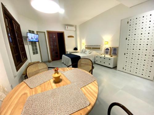 Habitación con cama, mesa y sillas. en Studios Aromas do Campeche - Floripa, en Florianópolis