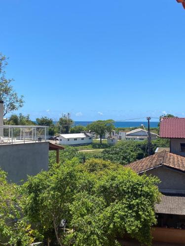 a view of the roofs of houses and trees at Studios Aromas do Campeche - Floripa in Florianópolis