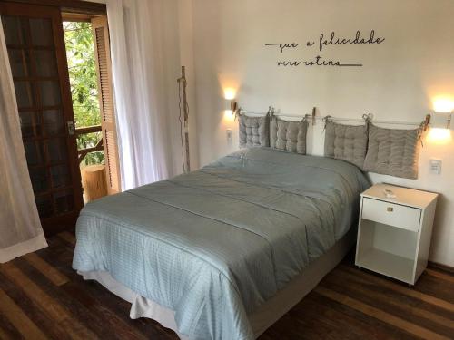 a bedroom with a bed with a sign on the wall at Studios Aromas do Campeche - Floripa in Florianópolis