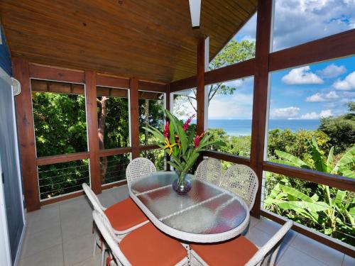 a dining room with a table and chairs and the ocean at Incredible Ocean Views From Both Sides Of This Hill Top Home, in West Bay