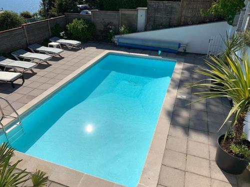 a swimming pool on a patio with lounge chairs at Treloyhan Lodge in St Ives
