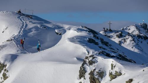 two people skiing down a snow covered mountain at Ferienhaus Wachterhof Aschau im Zillertal in Aschau
