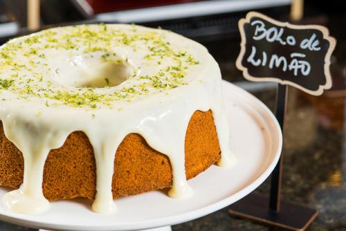 a cake with white icing on a white plate at Hotel Campo Largo Express in Campo Largo