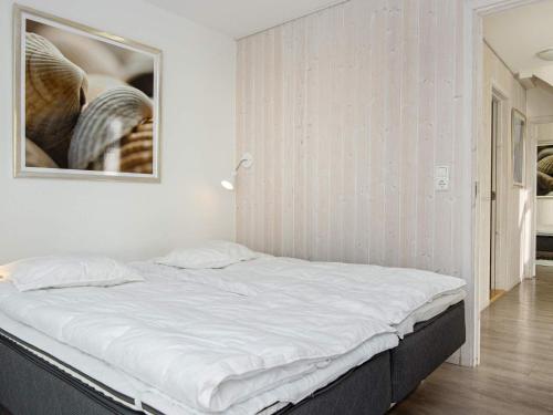 Bett in einem Zimmer mit einem Bild an der Wand in der Unterkunft Two-Bedroom Holiday home in Wendtorf 37 in Wendtorf