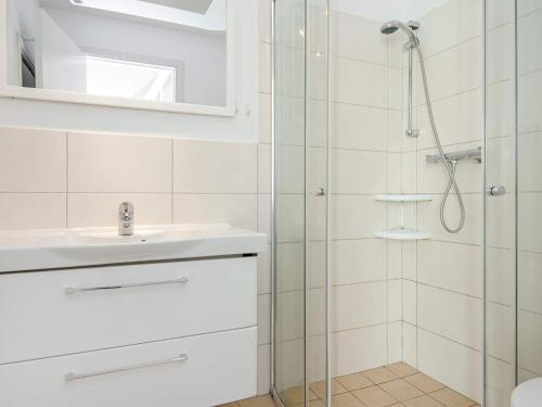 ein weißes Bad mit einer Dusche und einem Waschbecken in der Unterkunft Two-Bedroom Holiday home in Wendtorf 37 in Wendtorf