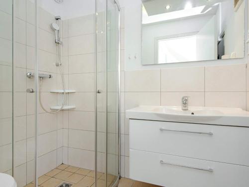a bathroom with a shower and a sink and a mirror at Holiday Home Strandblick VII in Wendtorf