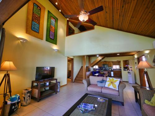 a living room with a couch and a tv at Incredible Ocean Views From Both Sides Of This Hill Top Home, in West Bay
