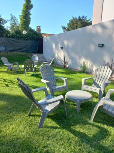 un grupo de sillas y una mesa en el césped en Acacia Morada en Villa Gesell