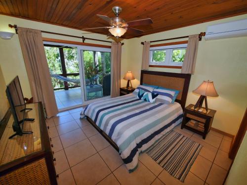 - une chambre avec un lit et un ventilateur de plafond dans l'établissement Casa Buena Vida, à West Bay