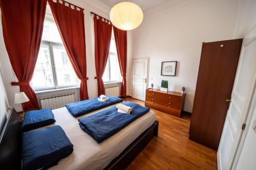 a bedroom with a large bed with blue pillows at AUTENTIC APARTMENTS Platnéřská in Prague