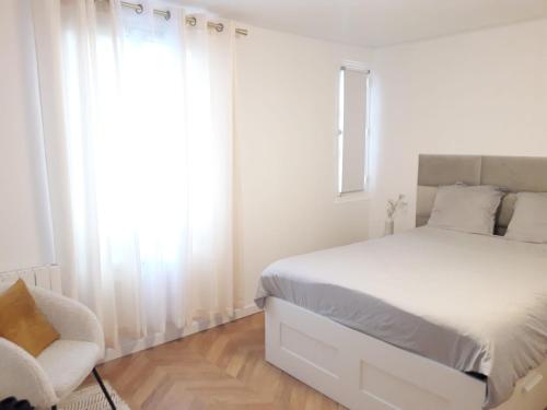 een witte slaapkamer met een bed en een stoel bij Champs Elysées Luxury appartment in Parijs