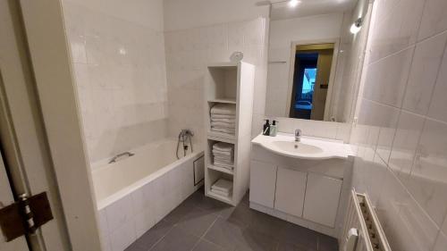 un bagno bianco con lavandino, vasca e specchio di Willem One a Mechelen