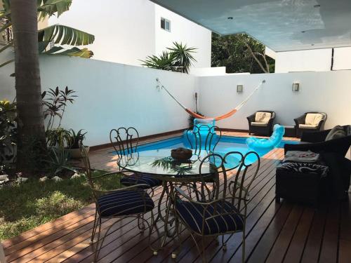een patio met een tafel en stoelen naast een zwembad bij Spacious Luxury Home in Cancun