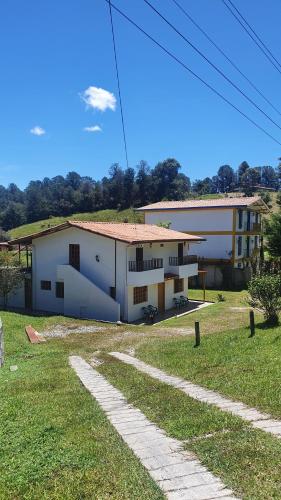 ein großes weißes Gebäude mit einem Rasenplatz in der Unterkunft Casa Lucía - Guatapé in Guatapé