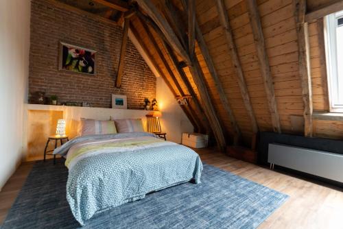 a bedroom with a bed and a brick wall at B&B Appartement Hemels in Twisk