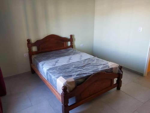 1 dormitorio con cama de madera y edredón azul en Casa Vacacional "Aguaditas" en La Punta