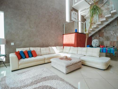 a living room with a white couch and a stool at Spacious Luxury Home in Cancún