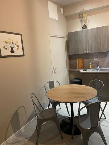 a kitchen with a table and chairs in a kitchen at Appartement spacieux in Cambrai
