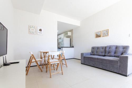 MangabeiraにあるBeach Townhouses - Duplex com Jacuzzi by Carpediemのソファとテーブルと椅子のあるリビングルーム
