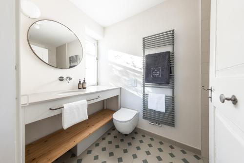 ein Bad mit einem WC und einem Spiegel in der Unterkunft Smart Suites Kaltern - Apartments am Kalterer See in Kaltern