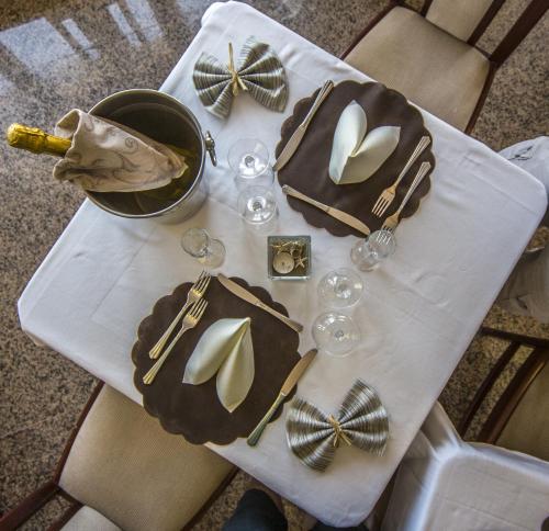 a table with a white table cloth with glasses and napkins at Hotel Touring in Misano Adriatico