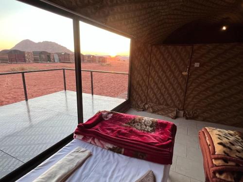 Habitación con cama y balcón con vistas. en Wadi Rum Shooting Stars Camp, en Wadi Rum