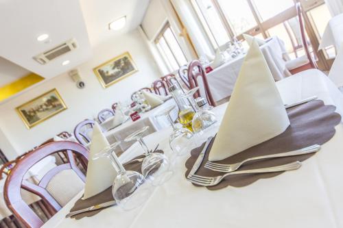 a dining room with a white table and chairs at Hotel Touring in Misano Adriatico