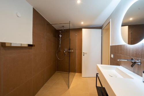 ein Bad mit einer Dusche und einem Waschbecken in der Unterkunft NOAS Home in Innsbruck