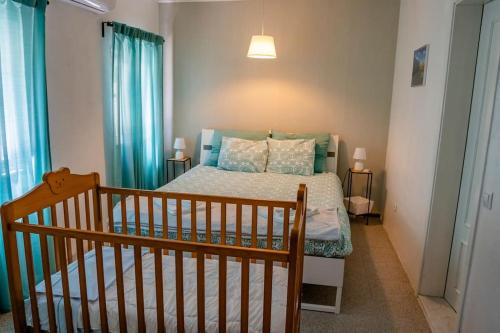 - une chambre avec un lit doté de rideaux bleus et un lit bébé dans l'établissement Quinta dos Pinheiros, à Estanqueiro