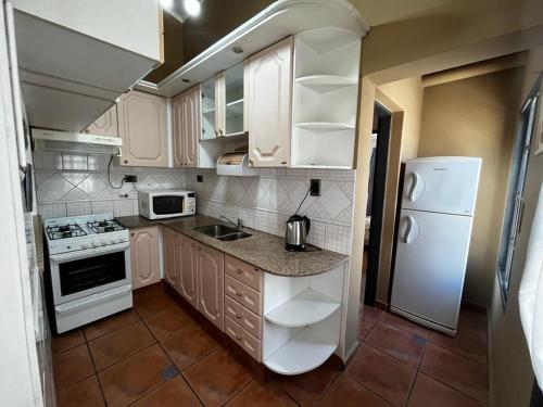 邁普的住宿－casa tropero sosa，厨房配有白色橱柜和白色冰箱。