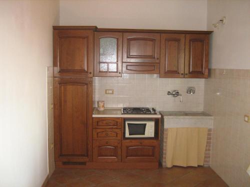 a kitchen with wooden cabinets and a stove at Poggio Picchio in Bibbona