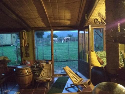 a room with two chairs and a view of a field at Se alquila casa completa para 12 personas - El Encuentro in Bella Vista
