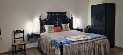 um quarto com uma cama com uma cabeceira preta em Casa O Arco Alojamento Local em Marvão