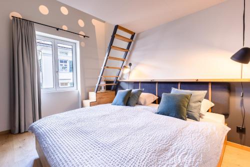 a bedroom with a large white bed with blue pillows at Gyger Restaurant Confiserie B&B in Thusis