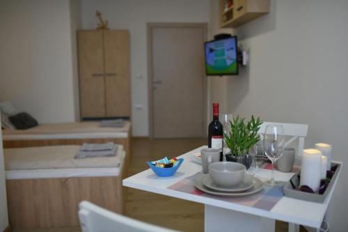 einen Tisch mit einem Teller Essen und einer Flasche Wein in der Unterkunft West in apartments in Čačak